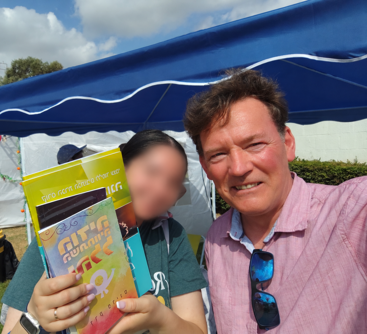 Andy mit einem Besucher und einem Buch von Derek Prince beim Festival of Life